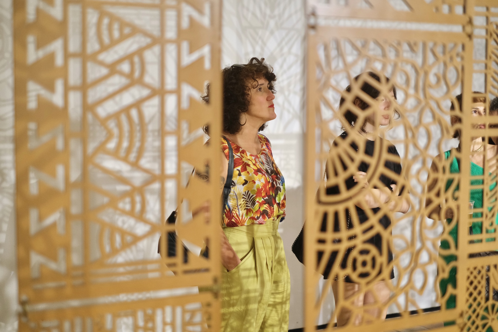 Visitante entre os painéis vazados da exposição Recife Anda Luz
